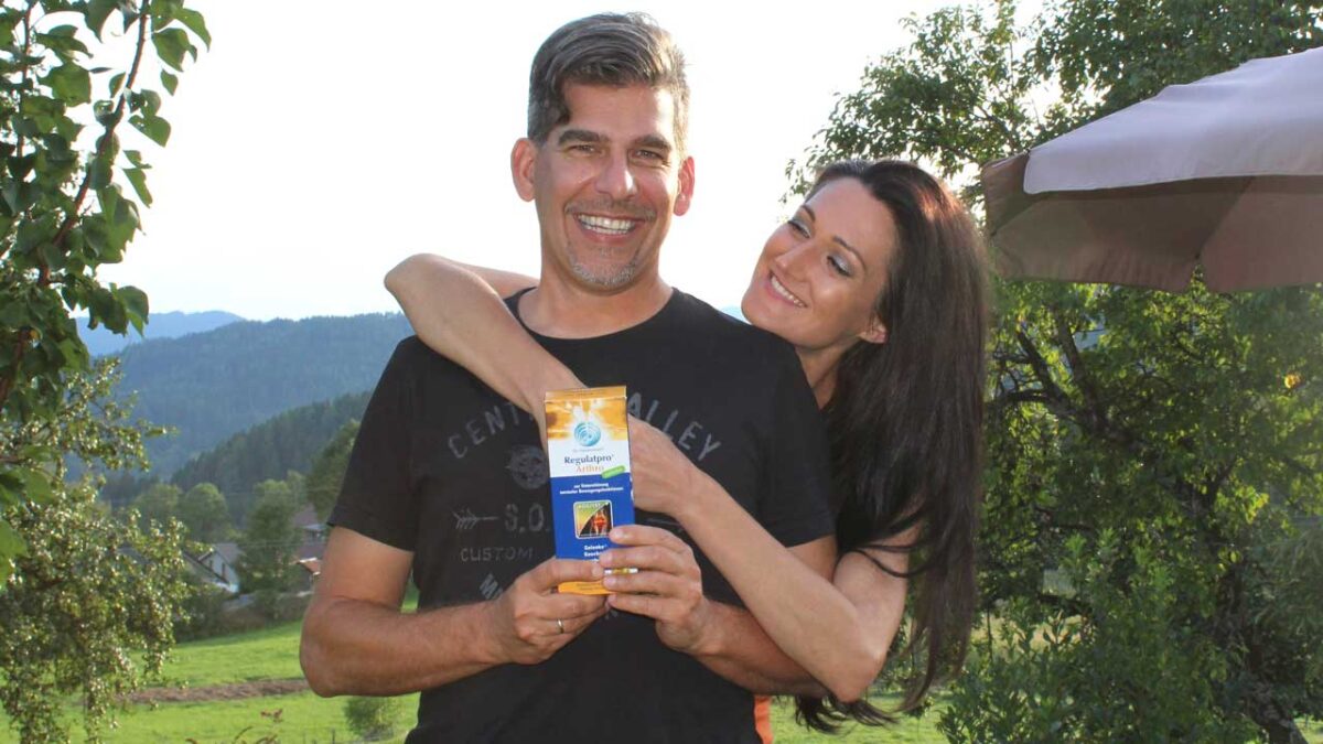 Paar genießt die Natur, Mann hält Packung Nahrungsergänzungsmittel in der Hand.