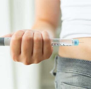 Jemand spritzt sich eine Insulinspritze
