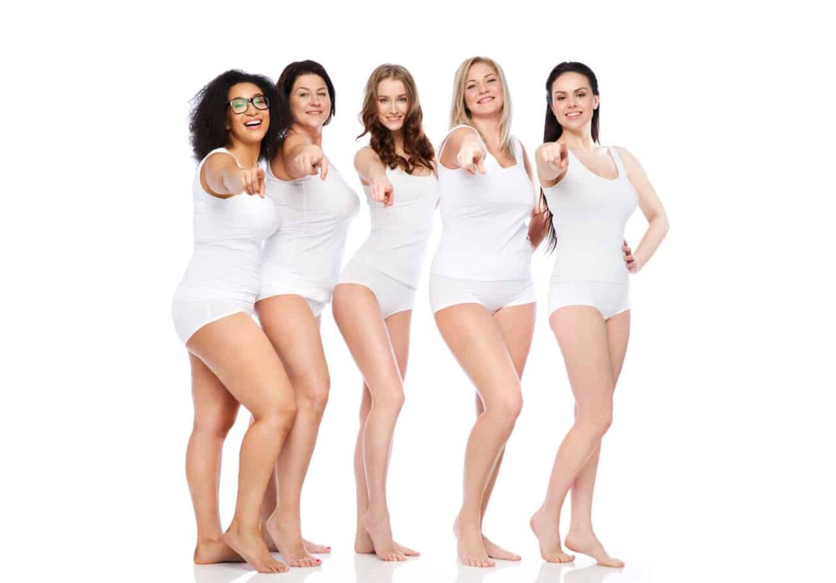 Fünf diverse Frauen in weißer Kleidung zeigen lächelnd ins Bild.