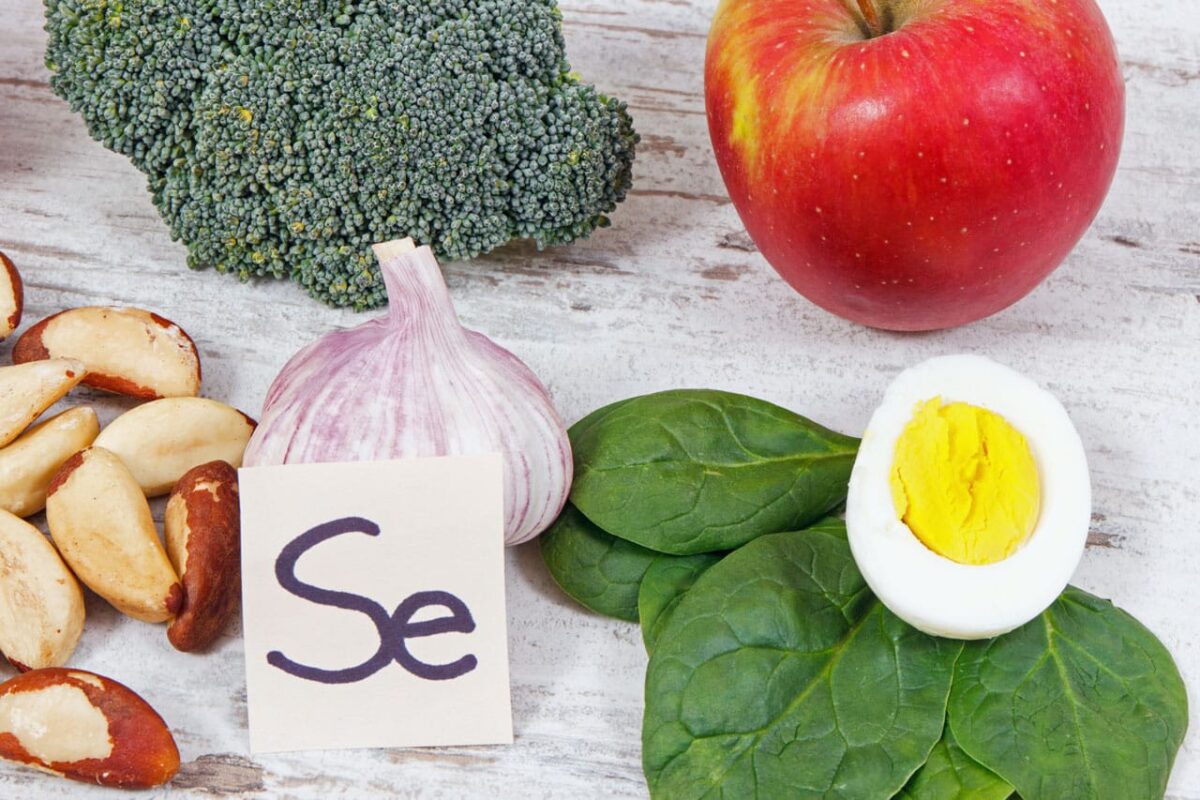 Gesunde Lebensmittel mit hohem Selengehalt: Nüsse, Knoblauch, Spinat, Ei.